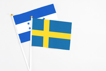 Sweden and Honduras stick flags on white background. High quality fabric, miniature national flag....