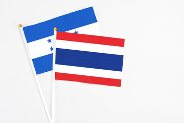 Thailand and Honduras stick flags on white background. High quality fabric, miniature national flag. Peaceful global concept.White floor for copy space.