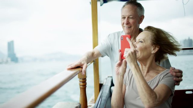 Senior couple taking travel photos with smart phone