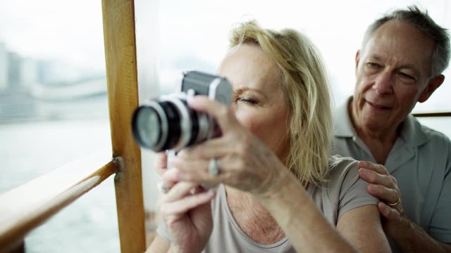 Senior Caucasian female taking travel pictures using camera 