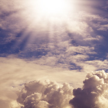 blauer Himmel mit Wolken und Sonnenstrahlen