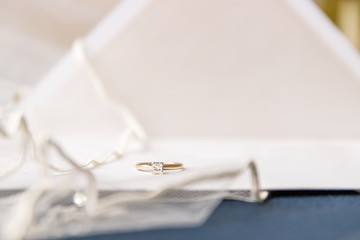 A bride silitair diamond ring with a vail and  wedding invitations
