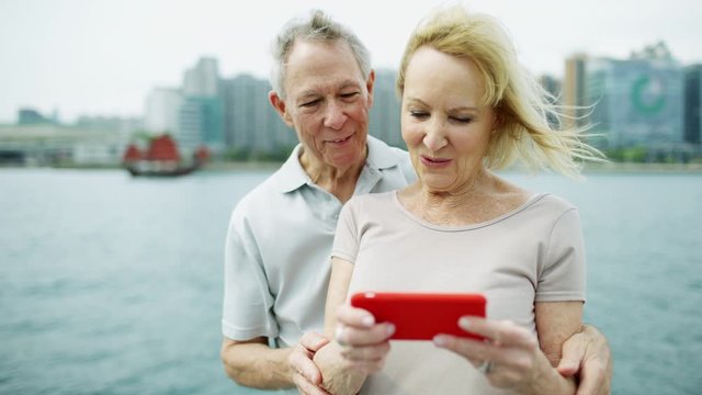 Caucasian senior couple viewing their photographic travel pictures 