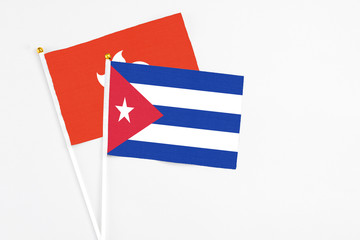 Cuba and Hong Kong stick flags on white background. High quality fabric, miniature national flag. Peaceful global concept.White floor for copy space.