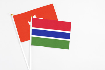 Gambia and Hong Kong stick flags on white background. High quality fabric, miniature national flag. Peaceful global concept.White floor for copy space.