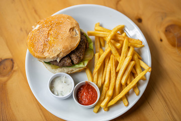 tasty hamburger with french fries on table