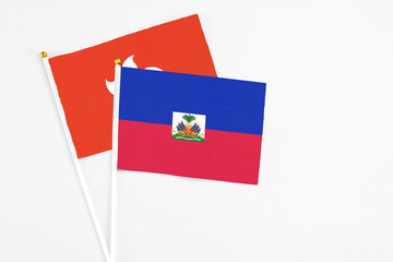 Haiti and Hong Kong stick flags on white background. High quality fabric, miniature national flag....