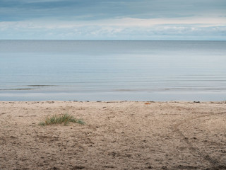 Calm sea surface and cloudy sky, sandy beach, nobody, Jurmala area Latvia.