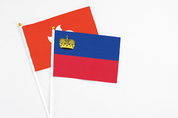 Liechtenstein and Hong Kong stick flags on white background. High quality fabric, miniature national flag. Peaceful global concept.White floor for copy space.