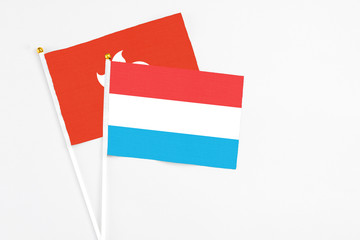 Luxembourg and Hong Kong stick flags on white background. High quality fabric, miniature national flag. Peaceful global concept.White floor for copy space.