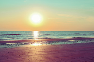 Sunset on the beach. Tinted photo in golden highlights. Sea and sandy beach. Banner, long format. Free space for text