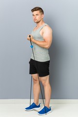 Young fitness caucasian man practicing with an elastic band.