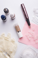permanent makeup set with tattooing machine around white background