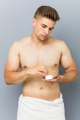 Young handsome man using hair wax