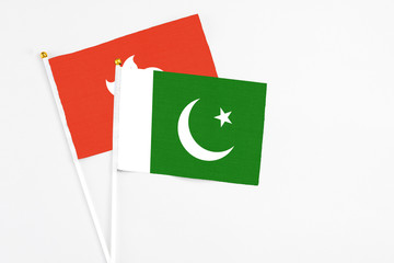 Pakistan and Hong Kong stick flags on white background. High quality fabric, miniature national flag. Peaceful global concept.White floor for copy space.