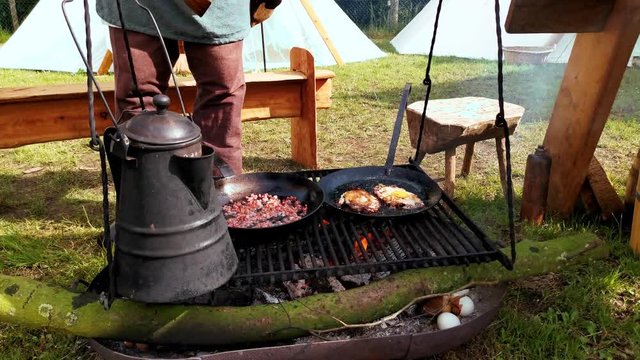 Mittelalter Kochstelle, ein Schwenkgrill mit Speck und Spiegelei