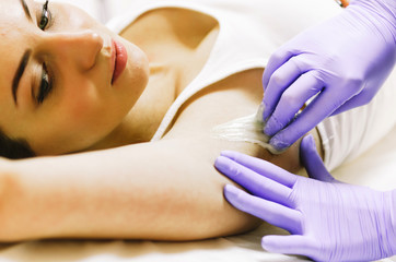 Obraz na płótnie Canvas woman doing hot sugar wax hair removal