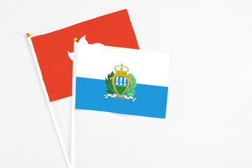 San Marino and Hong Kong stick flags on white background. High quality fabric, miniature national flag. Peaceful global concept.White floor for copy space.