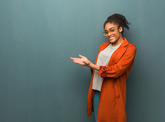 Young black african american girl with blue eyes holding something with hands