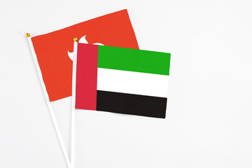 United Arab Emirates and Hong Kong stick flags on white background. High quality fabric, miniature national flag. Peaceful global concept.White floor for copy space.