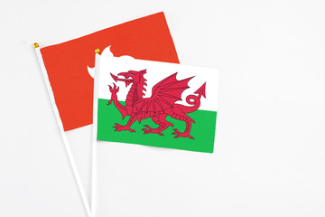 Wales and Hong Kong stick flags on white background. High quality fabric, miniature national flag. Peaceful global concept.White floor for copy space.