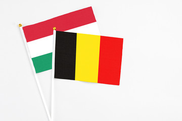 Belgium and Hungary stick flags on white background. High quality fabric, miniature national flag. Peaceful global concept.White floor for copy space.