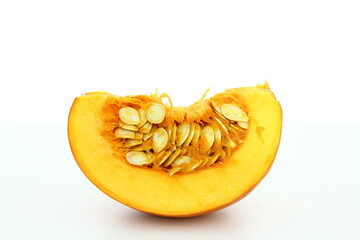 Piece of pumpkin with seeds on white background - bio vegetables - healthy food
