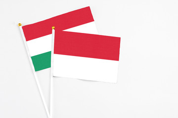 Indonesia and Hungary stick flags on white background. High quality fabric, miniature national flag. Peaceful global concept.White floor for copy space.