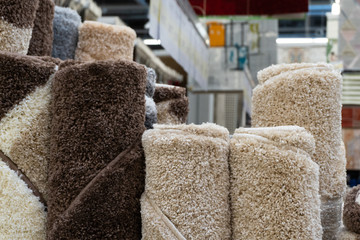 carpets on the shelves in the carpet store. different carpets hang and lie in the store