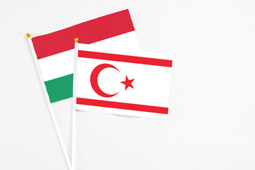 Northern Cyprus and Hungary stick flags on white background. High quality fabric, miniature national flag. Peaceful global concept.White floor for copy space.