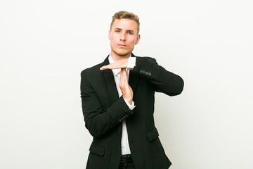 Young caucasian business man showing a timeout gesture.