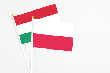 Poland and Hungary stick flags on white background. High quality fabric, miniature national flag. Peaceful global concept.White floor for copy space.