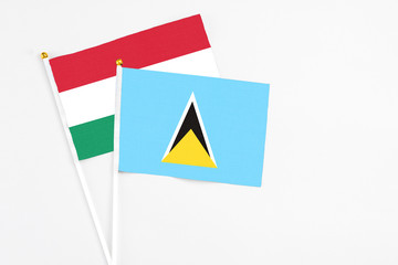 Saint Lucia and Hungary stick flags on white background. High quality fabric, miniature national flag. Peaceful global concept.White floor for copy space.