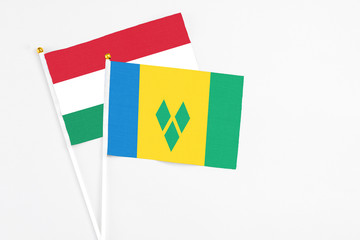 Saint Vincent And The Grenadines and Hungary stick flags on white background. High quality fabric,...