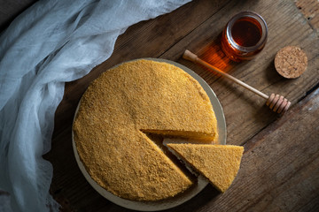 honey cake. jar of honey. hand with a spoon for honey. honey drips from a spoon