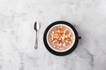 Cup of hot cocoa or hot chocolate with marshmallow in dark cup isolated on bright marble...