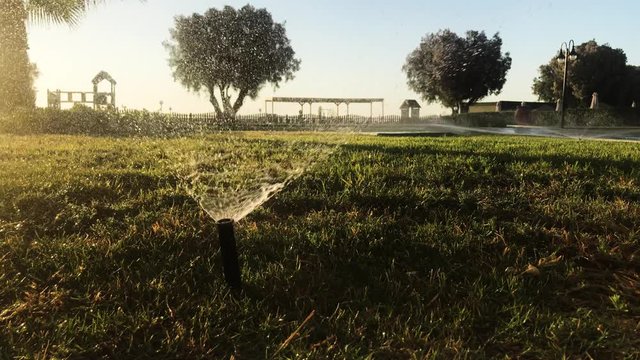 Rasensprenger im Abendsonnenschein in einer Hotelanlage auf der Insel Kos