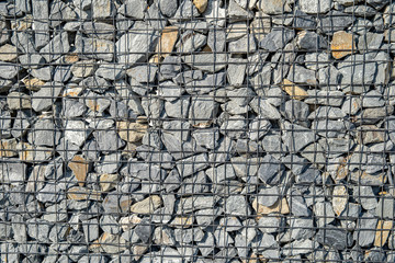Stone wall background. modern wall made of stone in a wire case