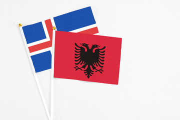 Albania and Iceland stick flags on white background. High quality fabric, miniature national flag. Peaceful global concept.White floor for copy space.