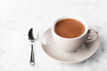 Cup of hot cocoa or hot chocolate or americano in white cup isolated on bright marble background.  Horizontal photo. traditional drinks for winter time