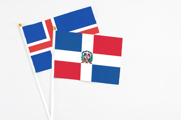 Dominican Republic and Iceland stick flags on white background. High quality fabric, miniature national flag. Peaceful global concept.White floor for copy space.