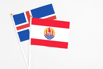Naklejka premium French Polynesia and Iceland stick flags on white background. High quality fabric, miniature national flag. Peaceful global concept.White floor for copy space.