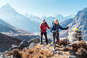 Rollo Ama Dablam Paar folgt der Everest Base Camp Trekkingroute in der Nähe von Dughla 4620m. Rucksacktouristen, die Rucksäcke tragen und Trekkingstöcke benutzen und den Blick auf das Tal mit dem Ama Dablam 6812m Gipfel genießen