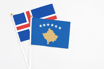 Kosovo and Iceland stick flags on white background. High quality fabric, miniature national flag. Peaceful global concept.White floor for copy space.