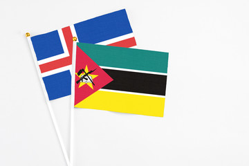 Mozambique and Iceland stick flags on white background. High quality fabric, miniature national...