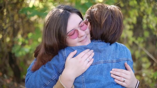 Charming young women kissing gently loving each other stroking touching face skin enjoying romantic tender moments on picnic date in the countryside.