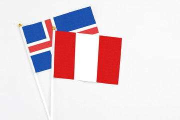 Peru and Iceland stick flags on white background. High quality fabric, miniature national flag. Peaceful global concept.White floor for copy space.