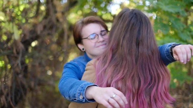 Charming young women kissing gently loving each other stroking touching face skin enjoying romantic tender moments on picnic date in the countryside.