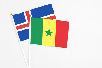 Senegal and Iceland stick flags on white background. High quality fabric, miniature national flag. Peaceful global concept.White floor for copy space.
