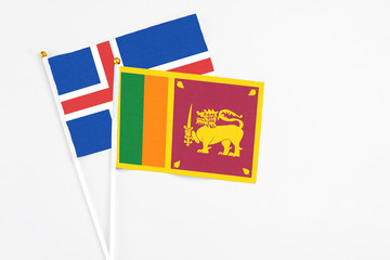 Sri Lanka and Iceland stick flags on white background. High quality fabric, miniature national flag. Peaceful global concept.White floor for copy space.